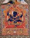 In the practice of the Guhyasamāja Tantra, the central deity of the Guhyasamāja is blue-black Akshobhyavajra, a form of Akshobhya, one of the five transcendent lords (pañcatathāgata).<br/><br/>

Akshobhyavajra holds a vajra and bell (ghanta) in his first two hands, and other hands hold the symbols of the four other transcendent lords: wheel of Vairocana and lotus of Amitabha in his right hands, and gem of Ratnasambhava and sword of Amoghasiddhi in his left hands.<br/><br/>

The maṇḍala consists of thirty-two deities in all.